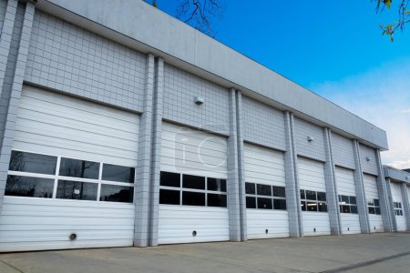 An image of a large delivery center with white bay doors. 