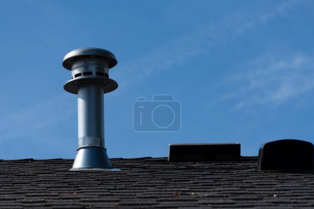 Téléchargez les photos : Une image d'une seule cheminée sur un toit résidentiel. - en image libre de droit