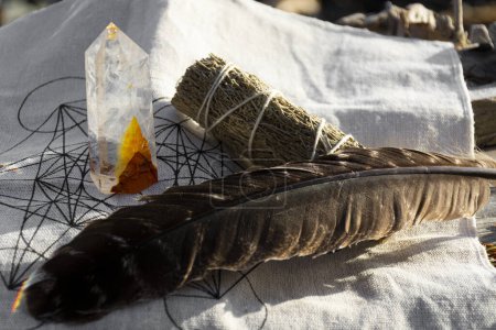 Photo for A healing image of a white sage smudge stick with smudge feather and clear quarts crystal on a crystal healing grid cloth. - Royalty Free Image