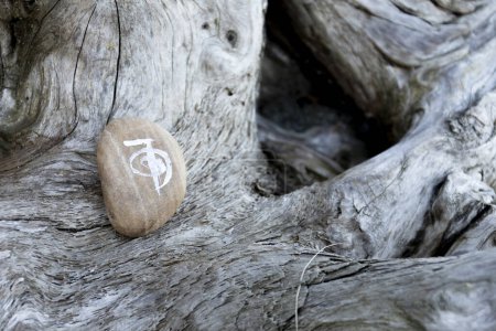 A close up image of a spiritual healing symbol painted on a smooth polished stone.