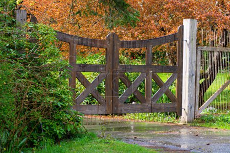 An image of an old brown wooden gate at the entrance of residential property. 