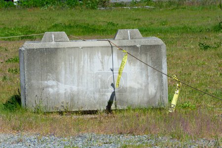 An image of a single concrete road barrier with old yellow caution.  