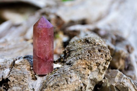 An image of a tall strawberry quartz crystal tower sparkling in natural sunlight.