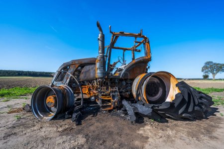 Foto de Totalmente destruido tractor quemado en un campo - Imagen libre de derechos