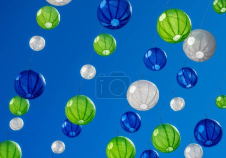 Foto de Fiesta con coloridas lámparas colgando bajo un cielo azul - Imagen libre de derechos