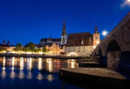 Regensburger Stadtbild zur blauen Stunde mit Lichtreflexen in der Donau