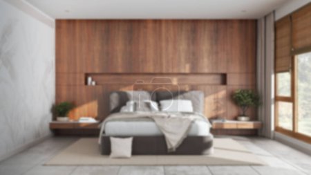 Foto de Blurred background, modern bedroom with wooden headboard. Velvet bed, bedding, pillows and carpet. Minimalist interior design - Imagen libre de derechos