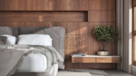 Foto de Blurred background, modern bedroom close up. Wooden headboard. Velvet bed, bedding, pillows and carpet. Contemporary interior design - Imagen libre de derechos