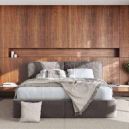 Foto de Blurred background, minimalist bedroom with wooden headboard. Velvet bed, bedding, pillows and carpet. Contemporary interior design - Imagen libre de derechos