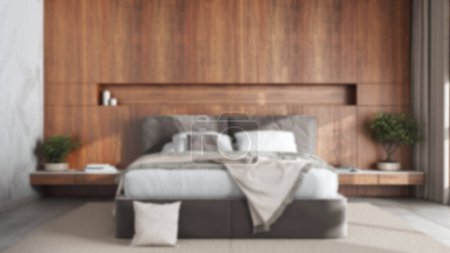 Foto de Blurred background, modern bedroom with wooden headboard. Velvet bed, bedding, pillows and carpet. Contemporary interior design - Imagen libre de derechos