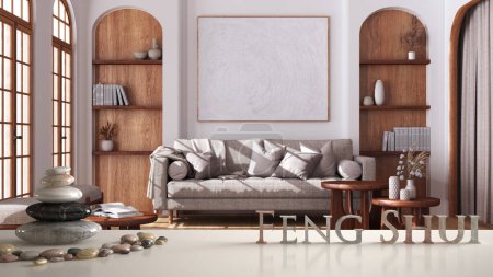 Foto de Estante de mesa blanco con balanza de guijarros y letras 3D que hacen que la palabra feng shui sobre la casa de campo sala de estar con sofá en estilo boho. Diseño de interiores de concepto mínimo, zen - Imagen libre de derechos