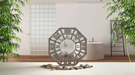 Foto de Mesa blanca, estante con ba gua, piedra de guijarro y plantas de bambú, sobre un baño blanco mínimo con bañera y pared de ladrillo de vidrio, diseño de interiores en concepto - Imagen libre de derechos