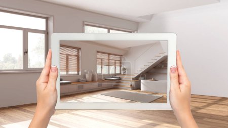 Augmented reality concept. Hand holding tablet with AR application used to simulate furniture and design products in empty interior with parquet floor, japandi bathroom
