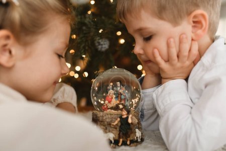Photo for The kids and christmas glass ball with a nativity scene - Royalty Free Image