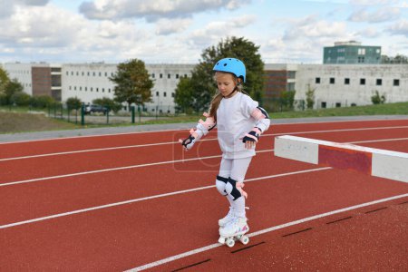 Photo for Girl in vintage white roller skates and a helmet at the stadium - Royalty Free Image
