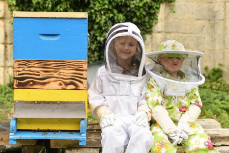 Téléchargez les photos : Enfants en combinaison de protection à la ruche - en image libre de droit