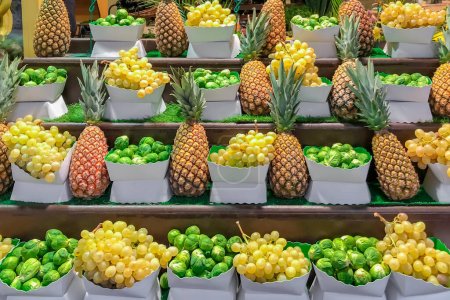 Photo for Fresh grapes pineapples and Brussels sprouts on the grocery store in the supermarket in France - Royalty Free Image