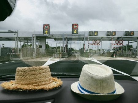 Photo for The hats of two travelers near the windshield in front of the Toll gate - Royalty Free Image