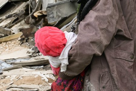 Téléchargez les photos : Mère et enfants près d'une maison détruite - en image libre de droit
