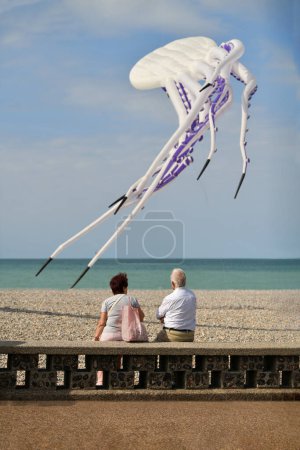 Älteres Ehepaar blickt auf einen weißen Oktopus Drachen am Himmel Drachenfest in Dieppe
