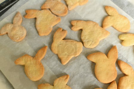 Cookies in the shape of hares on parchment paper for Easter