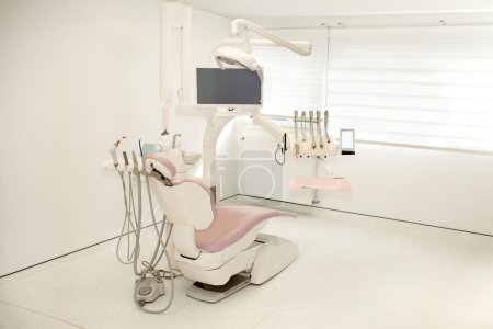 Pink dental chair in a modern dental cabinet