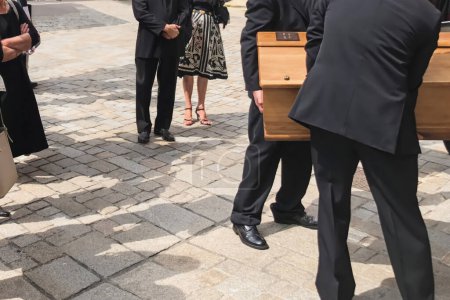 Service funéraire chargeant le cercueil dans le corbillard