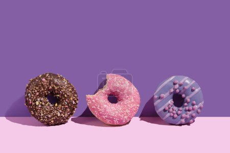 Photo for Various colorful glazed doughnuts with sprinkles on a pink background - Royalty Free Image