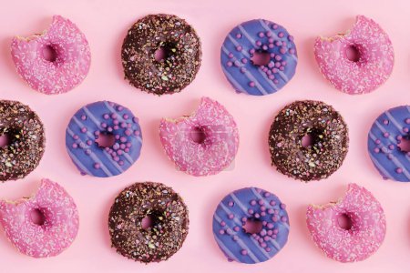 Photo for Top view of many colorful donuts on a pink background, copy space - Royalty Free Image