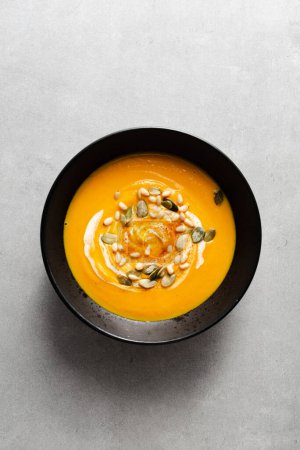 Photo for Pumpkin soup in a bowl on the gray concrete background. top view. - Royalty Free Image