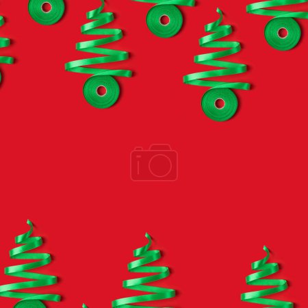 Foto de Tarjeta de Año Nuevo con concepto de árboles de Navidad hechos de cinta verde sobre fondo rojo. Vista superior, espacio de copia - Imagen libre de derechos