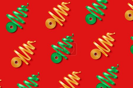 Foto de Patrón de Año Nuevo con concepto de árboles de Navidad hechos de cinta dorada y verde sobre fondo rojo. Vista superior - Imagen libre de derechos