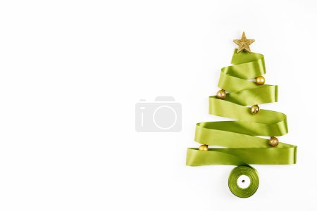 Téléchargez les photos : Carte du Nouvel An avec concept d'arbre de Noël en ruban vert sur fond blanc. Vue du dessus, espace de copie - en image libre de droit