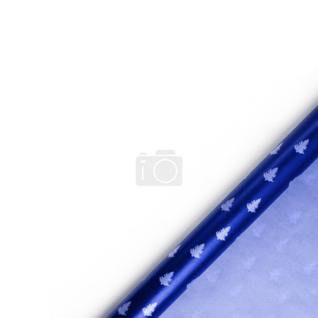 Téléchargez les photos : Rouleau de papier d'emballage de Noël bleu isolé sur fond blanc. Carte Nouvel An, vue du dessus, espace de copie - en image libre de droit