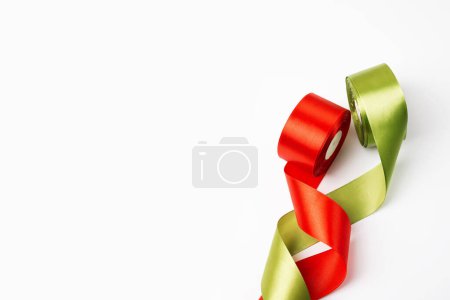 Téléchargez les photos : Carte du Nouvel An en rubans de satin rouge et vert sur fond blanc. Vue du dessus, espace de copie - en image libre de droit