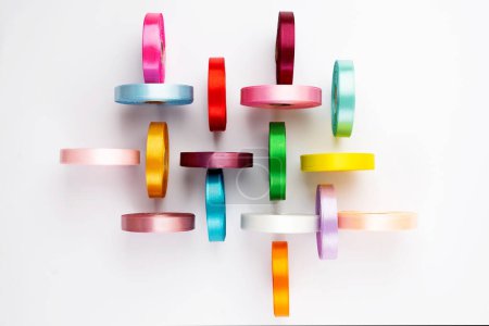 Foto de Conjunto de muchos carretes de cinta de satén de colores sobre fondo blanco. Carretes de cinta textil, vista superior - Imagen libre de derechos