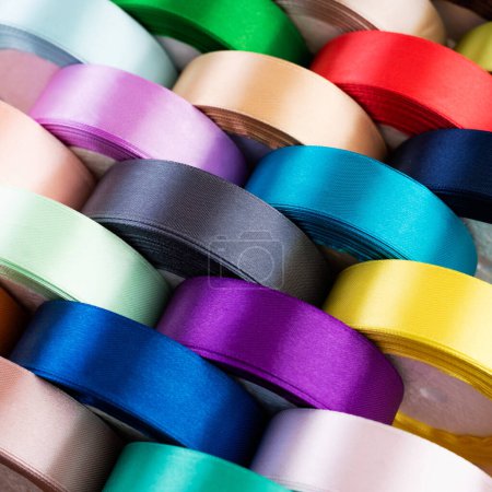 Foto de Primer plano de muchos carretes de cinta textil de colores. Conjunto de carretes de cinta de satén - Imagen libre de derechos