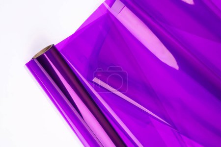 Téléchargez les photos : Papier d'emballage violet brillant pour cadeaux ou fleurs sur fond blanc. Vue de dessus, gros plan - en image libre de droit