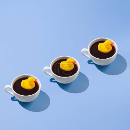 Photo for Creative trendy pattern made of coffee cup with a yellow rubber duck on a blue background - Royalty Free Image