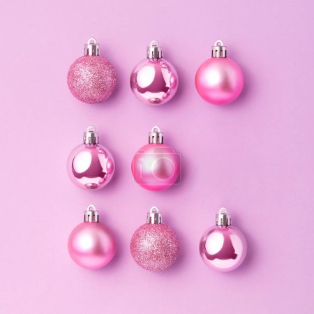 Foto de Decoración de adornos de Navidad rosa sobre fondo rosa. Concepto creativo de vacaciones - Imagen libre de derechos