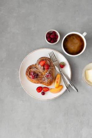 Foto de Desayuno de San Valentín sobre fondo gris. Pan con mantequilla y bayas en un plato blanco y una taza de café. Vista superior, espacio de copia - Imagen libre de derechos