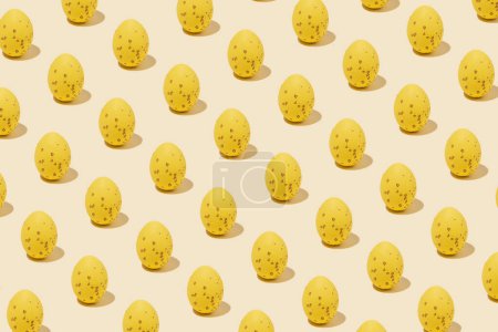 Pattern of yellow shiny Easter egg casting shadow on yellow background, minimalism concept, copy space