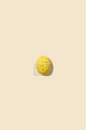 Photo for One yellow speckled Easter egg casting shadow on yellow background, minimalism concept, copy space - Royalty Free Image