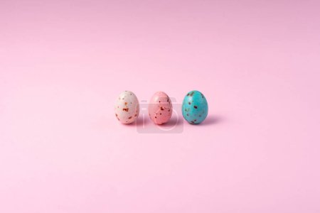 Photo for Chocolate colored Easter eggs speckled on a pink background. Minimalism Easter concept, copy space - Royalty Free Image