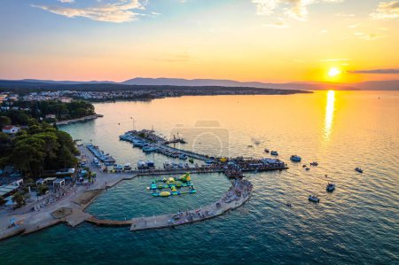 Téléchargez les photos : Plage en bord de mer de Malinska et vue sur le coucher du soleil sur le littoral turquoise, île de Krk destination touristique en Croatie - en image libre de droit