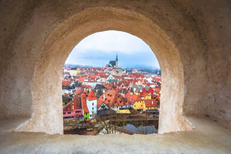 Town of Cesky Krumlov and Vltava river panoramic view through stone window,  South Bohemian Region of the Czech Republic