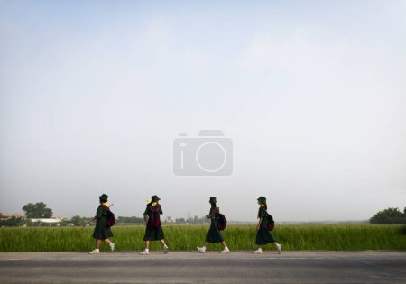 Téléchargez les photos : Fille scout vert costume marche passer agriculture champ bangagara thailand - en image libre de droit