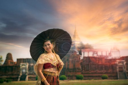 Téléchargez les photos : Belle femme asiatique tenant parapluie en bambou debout contre le vieux temple dans ayutthaya site du patrimoine mondial de thailand de l'Unesco, ayutthaya est l'une des destinations de voyage les plus populaires au centre de thailand - en image libre de droit