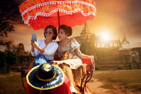 Téléchargez les photos : Couples asiatique femme équitation sur éléphant contre belle vieux temple dans ayutthaya site du patrimoine mondial de l'Unesco central de Thaïlande - en image libre de droit