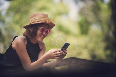 Téléchargez les photos : Belle femme lisant message dans le téléphone intelligent et souriant de bonheur - en image libre de droit